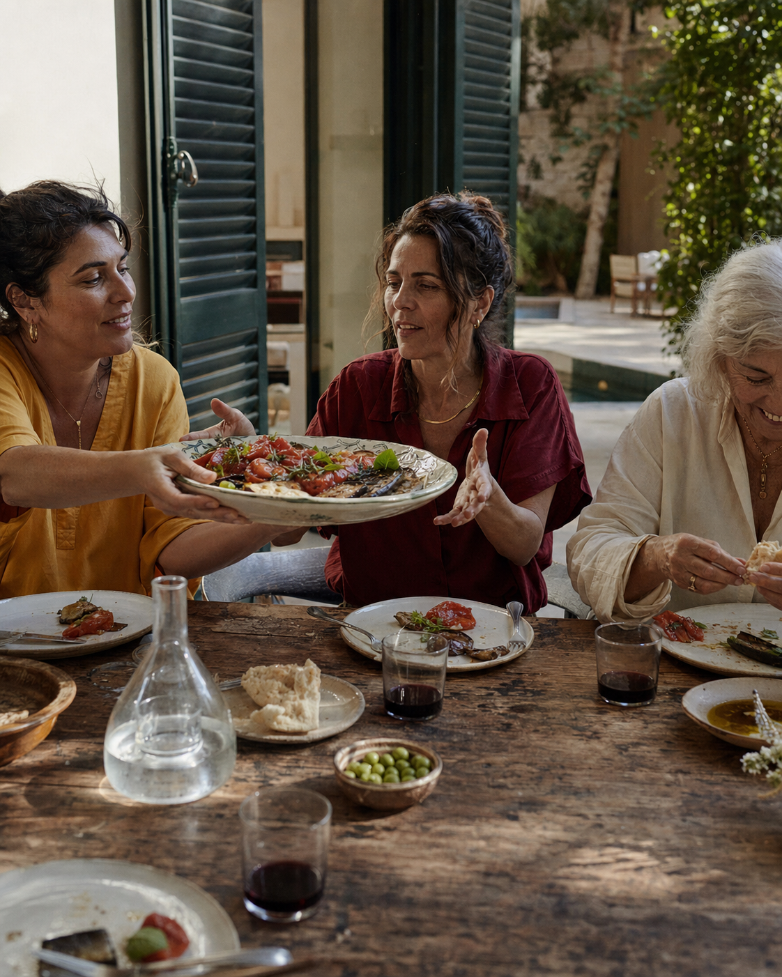 Women sharing a meal and conversation around a sunlit table